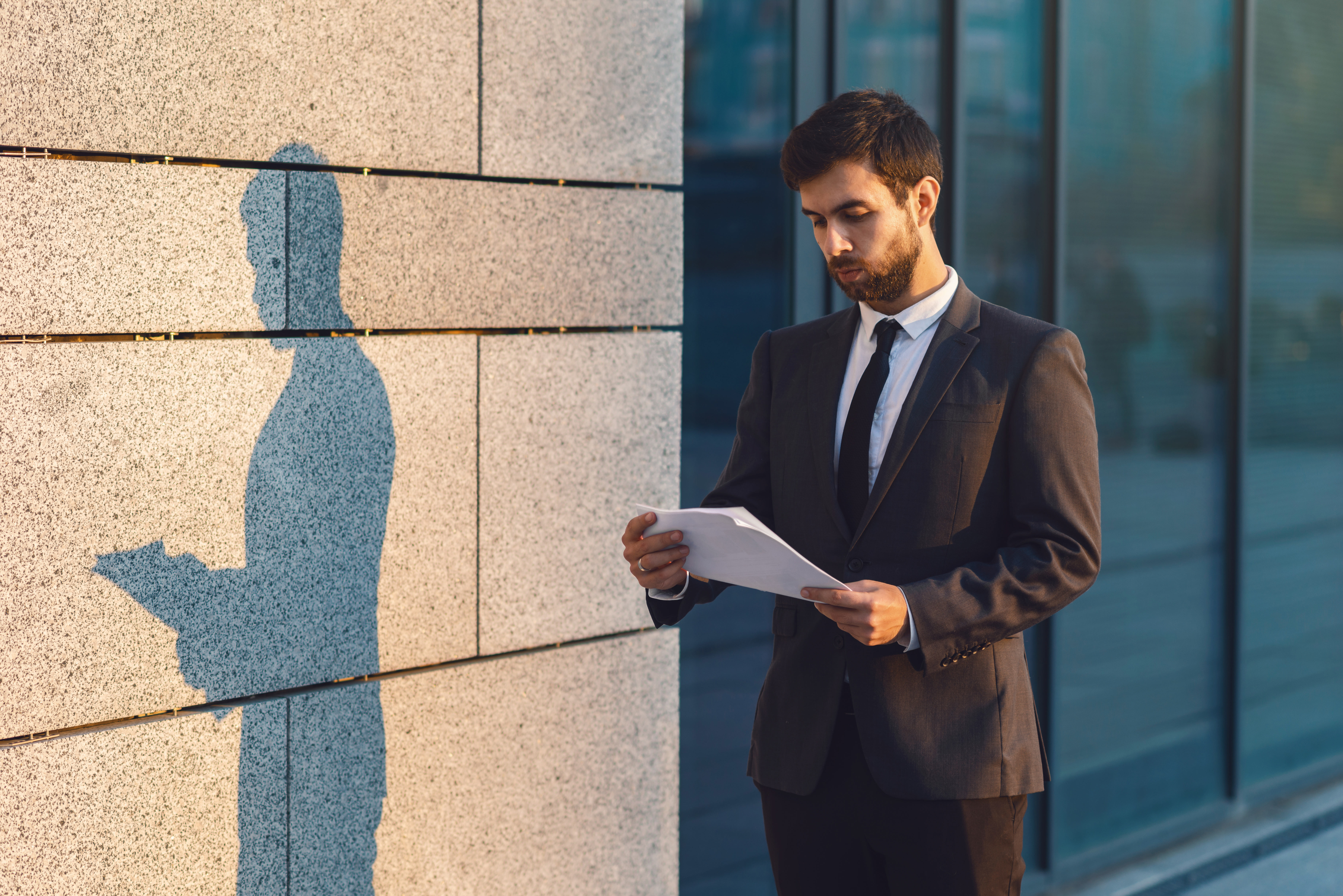 Man in suit observes how traditional paper document falls short amidst rapid business growth on the cloud